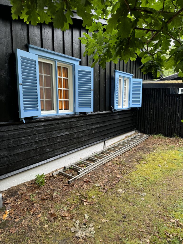 Sortmalet træfacade med nymalede vinduer